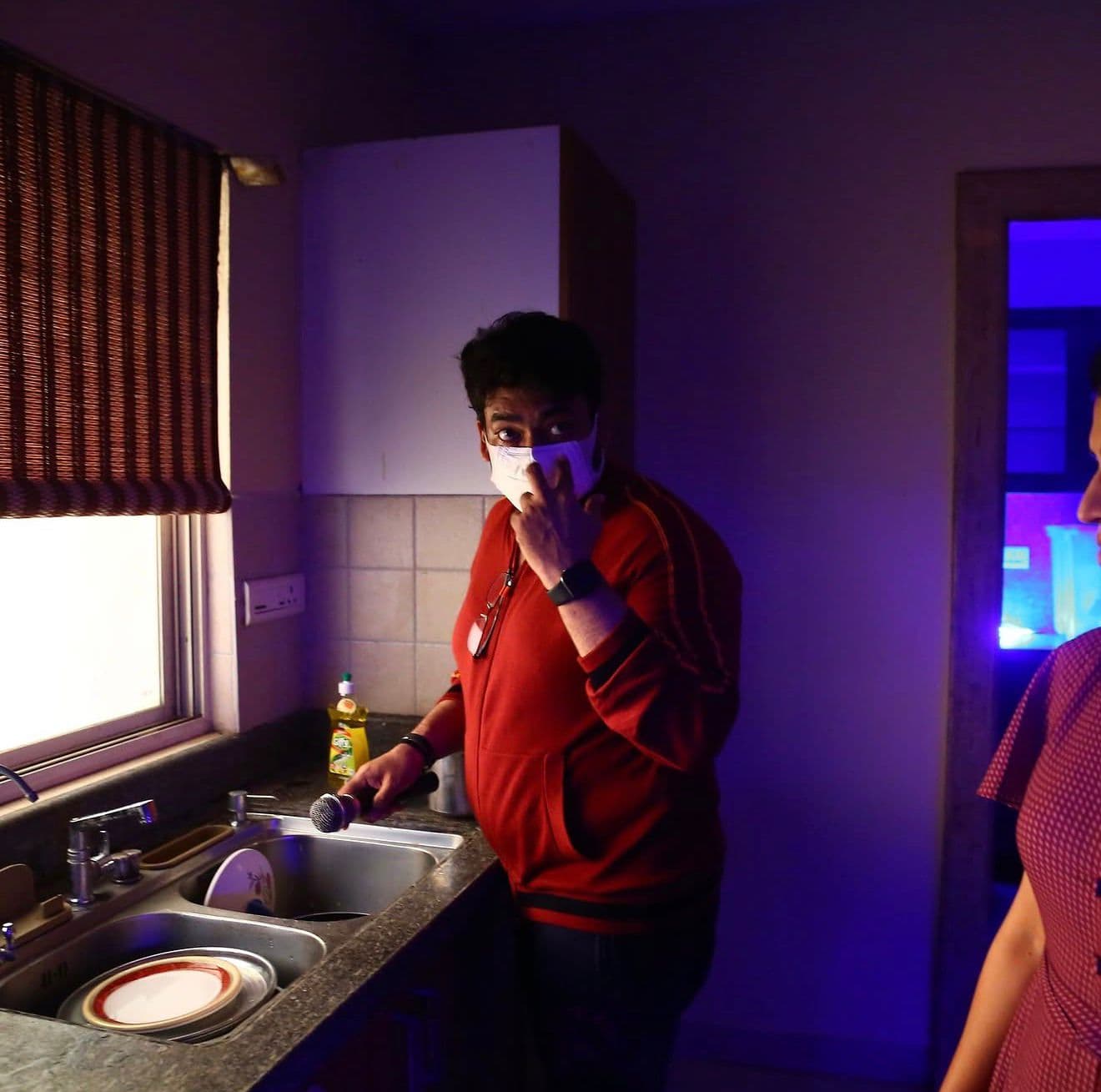 Close-up of the actor pausing mid-scene at the kitchen sink